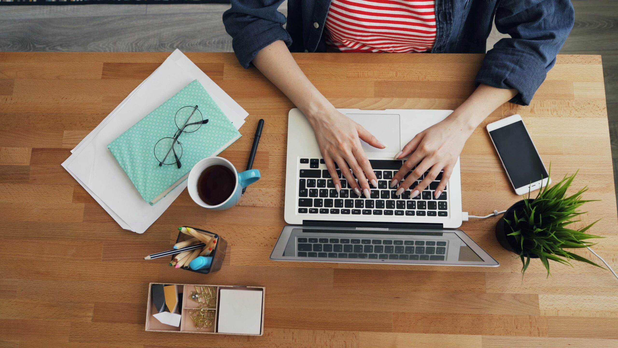 Email marketing guide, en person arbejder ved laptop med noter og telefon